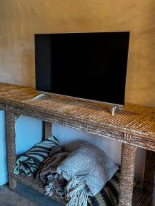 a television on top of a table with pillows at Casa Monã in Maceio