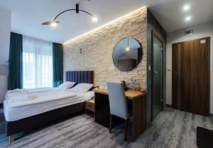 a bedroom with a bed and a desk and a mirror at Przystań Leśniów in Żarki