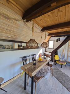 a dining room with a wooden table and chairs at Solarna Eko Vila - Your Boutique Mountain Escape in Divčibare