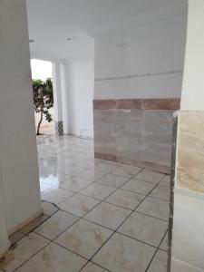 an empty room with a tile floor and a wall at Luxury in El Haouaria