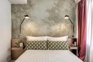 a bedroom with two lamps and a bed with two pillows at Barberini 16- Boutique Hotel in Rome
