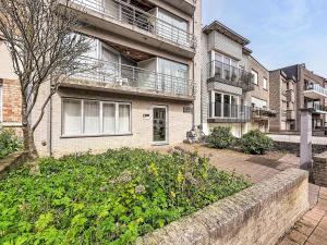 an apartment building with a garden in front of it at Apartment Westhinder with balcony by Interhome in Blankenberge