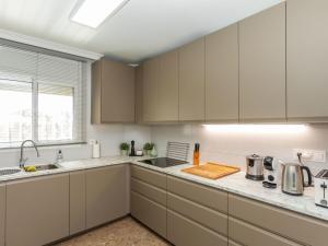 a kitchen with white cabinets and a sink at Villa Mys by Interhome in Miami Platja