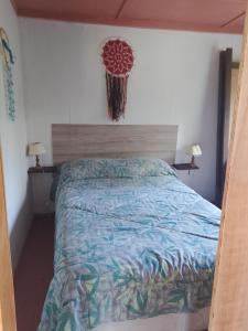 a bedroom with a bed with a blue comforter at Sol naciente in Jaureguiberry