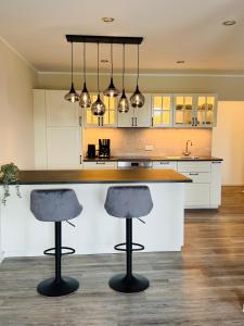 a kitchen with a counter and two bar stools at Hof Sandfort in Bad Laer