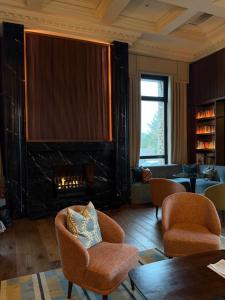 a living room with a fireplace and chairs at Mount Errigal Hotel, Conference & Leisure Centre in Letterkenny