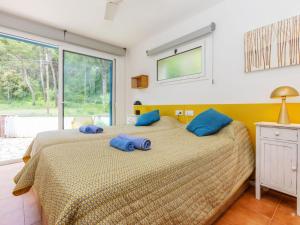 a bedroom with a bed with blue pillows on it at Holiday Home Florencia by Interhome in Pals