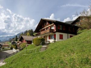 a house on the side of a grassy hill at Apartment Chalet Albi-2 by Interhome in Grindelwald