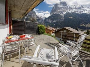 a balcony with a table and chairs and mountains at Apartment Chalet Albi-2 by Interhome in Grindelwald