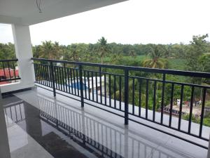 a balcony with a view of a field and palm trees at Serene Enclave in Nedumbassery +21 photos