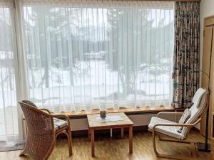 a room with a large window with two chairs and a table at Apartment Studio by Interhome in Bever