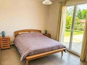 a bedroom with a bed and a sliding glass door at Holiday Home Philibert by Interhome in Carcans