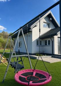 a swing set in a yard in front of a house at Domek Pod Gwiazdami Bieszczady in Hużele