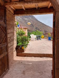 an open door to a patio with a table and a chair at Auberge amazrane in Matat