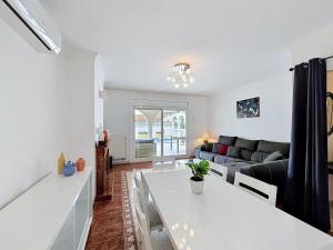 a living room with a white table and a couch at Holiday Home Requesens by Interhome in Empuriabrava
