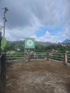 a sign in front of a fence with a view at The Green County Homestay in Panglipurgalin