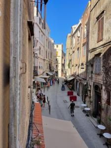 a city street with people walking down a street at Vivez Bonifacio - Sous le charme in Bonifacio