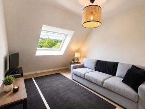 a living room with a couch and a window at Residence L'Horizon in Murat-le-Quaire