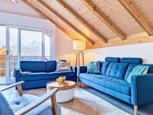 a living room with blue couches and a table at Apartment Momento by Interhome in Kandersteg