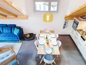 a living room with a table and a blue couch at Apartment Momento by Interhome in Kandersteg