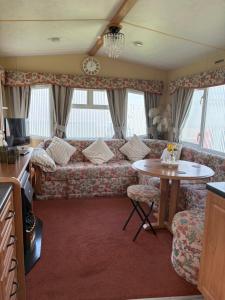 a living room with a couch and a table at Jos caravan in Ingoldmells