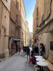 a group of people walking down an alley with tables at Vivez Bonifacio - Sous le charme in Bonifacio +6 photos
