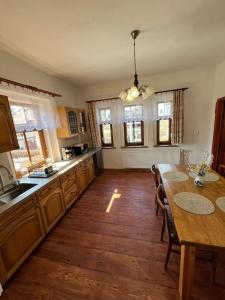 a kitchen with a table and a dining room at Vila Kučera in Chřibská