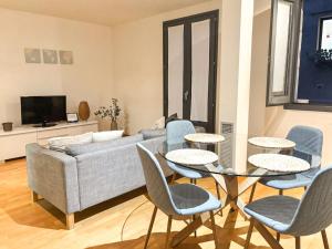 a living room with a couch and a table and chairs at Two bedroom apartment behind the Rambla in Girona