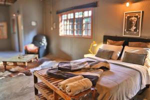 a bedroom with a large bed with a blanket on it at Loft Industrial in Santo André