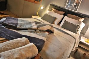 a bed with a blanket on it in a room at Loft Industrial in Santo André