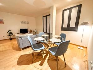 a living room with a table and chairs and a couch at Two bedroom apartment behind the Rambla in Girona