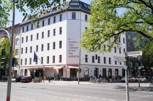 a white building on the corner of a street at The Dean Berlin in Berlin