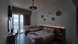 a living room with a bed and a couch at Edelweiss Rent Rooms-Rent a Car in Tsoutsouros