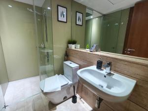 a bathroom with a sink and a toilet and a shower at Vortex Residence KLCC by Valen in Kuala Lumpur