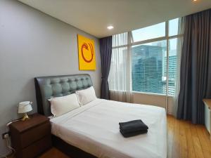 a bedroom with a bed with a black bag on it at Vortex Residence KLCC by Valen in Kuala Lumpur
