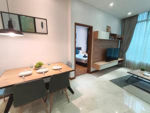 a dining room and living room with a table and chairs at Vortex Residence KLCC by Valen in Kuala Lumpur