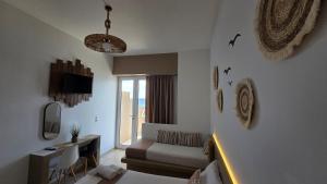 a living room with a couch and a window at Edelweiss Rent Rooms-Rent a Car in Tsoutsouros