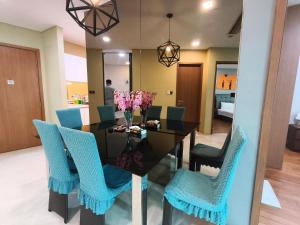 a dining room with a black table and blue chairs at Vortex Residence KLCC by Valen in Kuala Lumpur +29 photos