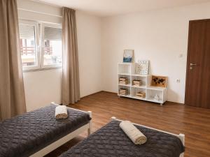 a bedroom with two beds and a book shelf at Vila Elena in Gevgelija