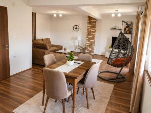 a dining room and living room with a table and chairs at Vila Elena in Gevgelija