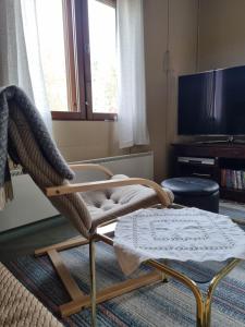 a living room with a rocking chair and a television at Mattilan talo b&b in Impiö