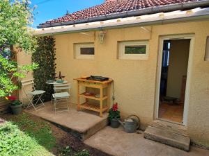 a small house with a porch with a table and chairs at Le Cosy Nid in Leyme