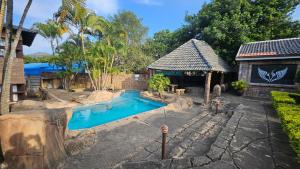 a swimming pool in front of a house at Beginners Cove Lodge in Nelspruit