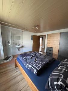 a large bed in a room with a bathroom at Ferienwohnung Patrycja in Weissenbach am Lech