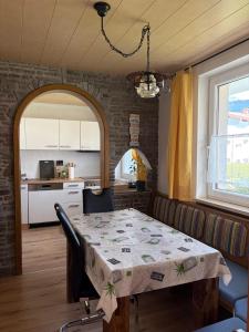 a dining room with a table and a kitchen at Ferienwohnung Patrycja in Weissenbach am Lech