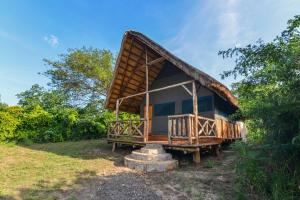 a small hut with a thatched roof on a field at Elephant View Lodge in Kasenyi
