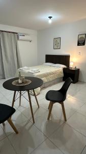 a bedroom with a bed and a table and chairs at Norte Urban Suites in Resistencia