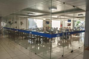 a large room with glass walls and tables and chairs at Hotel SESI PB - Parque da Mata in Rio Tinto +32 photos