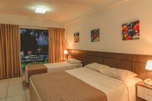 a hotel room with two beds and a window at Hotel SESI PB - Parque da Mata in Rio Tinto