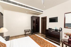 a hotel room with a bed and a television at Central boutique hotel in Morādābād